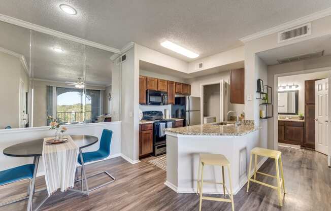 a kitchen with a breakfast bar and a table with chairs