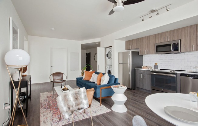 Living room and kitchen area with open-concept floorplan, luxury plank flooring and stainless steel appliances