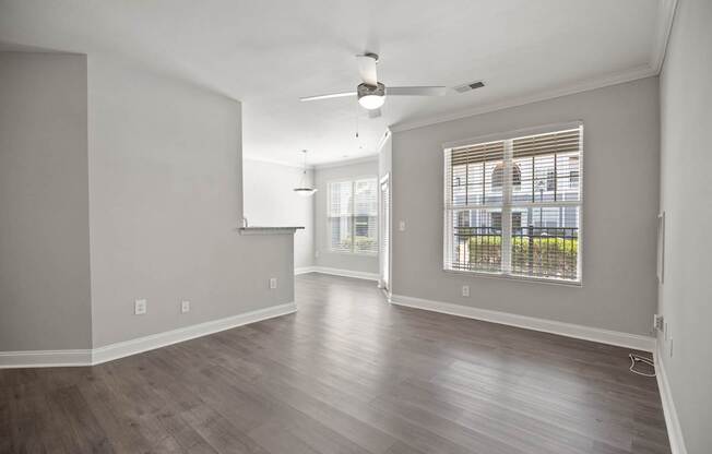 A room with a ceiling fan and a window with blinds.
