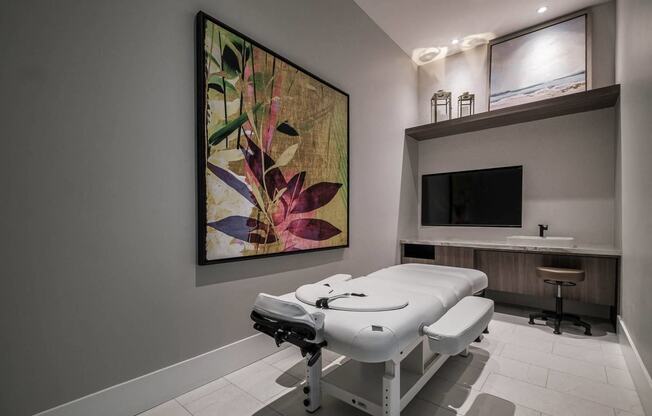 a spa room with a massage table and a tv at Altis Santa Barbara, Florida, 34104