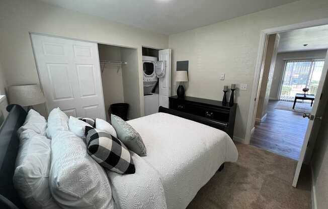 A bedroom with a bed, dresser, and closet.