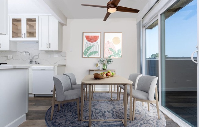 a dining area with a table and chairs and a ceiling fan