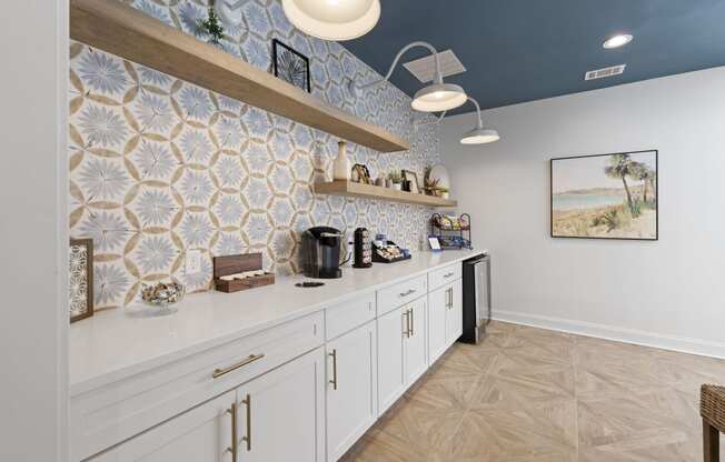 a kitchen with white cabinets and blue tiles on the wall