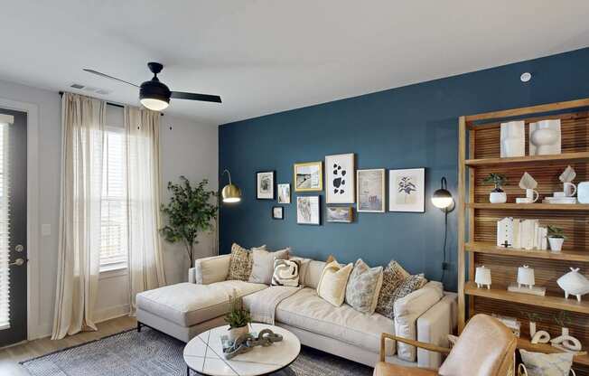a living room with a blue accent wall and a white couch
