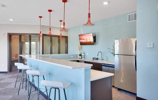 A kitchen with a blue wall and a stainless steel refrigerator.