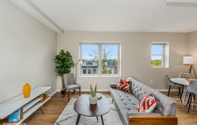 a living room with a couch and a coffee table in front of a window