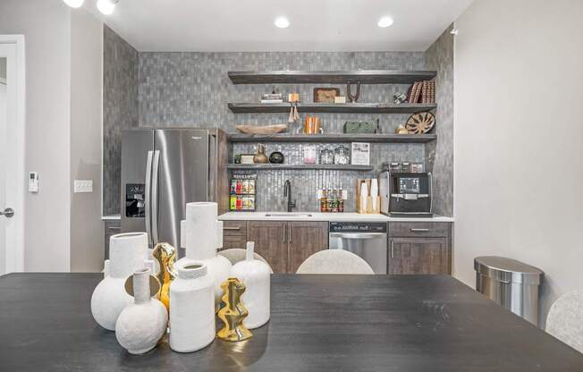 a kitchen with a large black table and stainless steel appliances