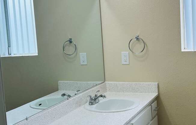 Bathroom with large vanity and window at Plaza Verde Apartments in Escondido, California.