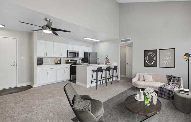 Model Living Room with Carpet and View of Kitchen with Wood-Style Flooring at Crystal Creek Apartments in Phoenix, AZ.