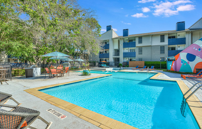 a swimming pool with an apartment building in the background