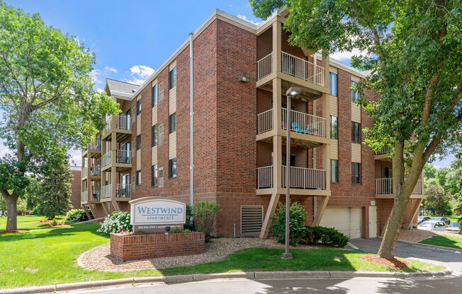 A brick building with the sign Westwind Apartments in front of it.