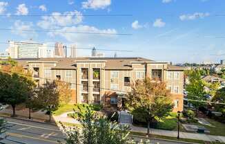 A large apartment building with a parking lot in front.