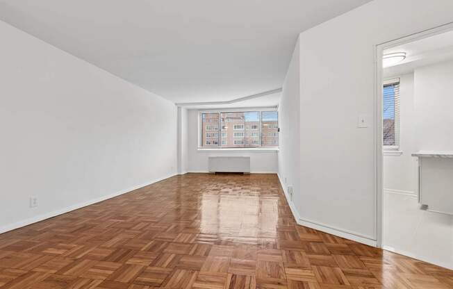 One bedroom living area wooden flooring and white walls.