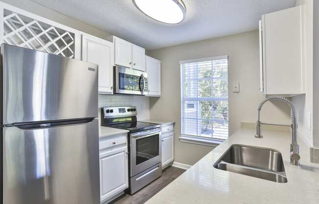 a kitchen with white cabinets and stainless steel appliances