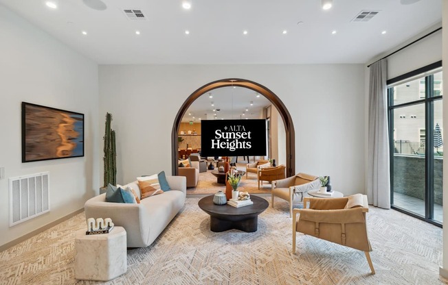 a living room with couches and chairs and an arched doorway