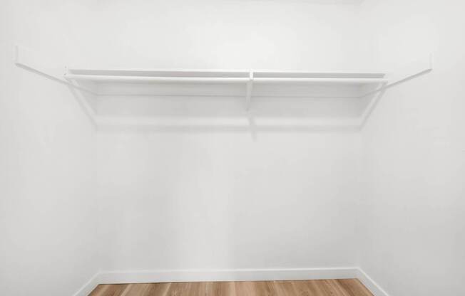 an empty room with white walls and a wooden floor