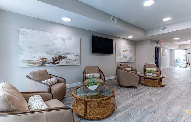 A living room with a large painting on the wall and a flat screen TV.