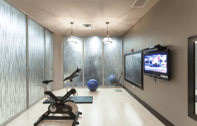 a workout room with a tv and a exercise bike