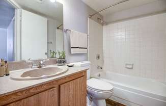 A bathroom with a white toilet and a white bathtub.