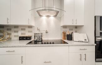 a kitchen with white cabinets and a quartz countertop at Magnolia Square, Naples, 34109