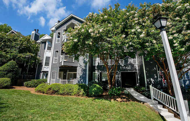A grey house with a white fence in front.