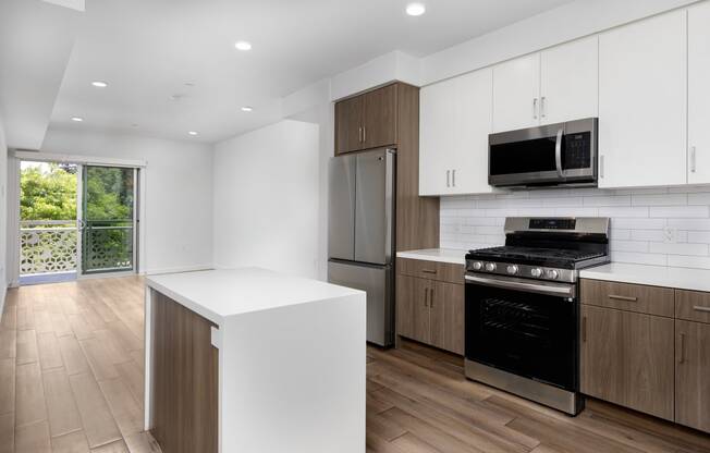 a kitchen with white cabinets and stainless steel appliances and a window