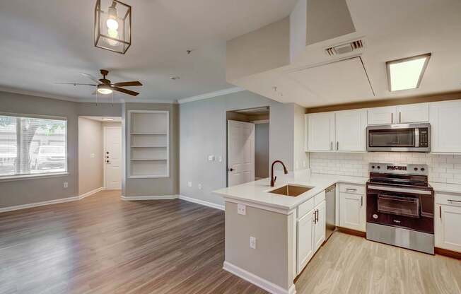 A kitchen with a white counter top and stainless steel appliances.