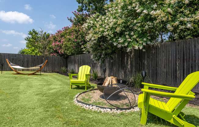 a backyard with a hammock and firepit