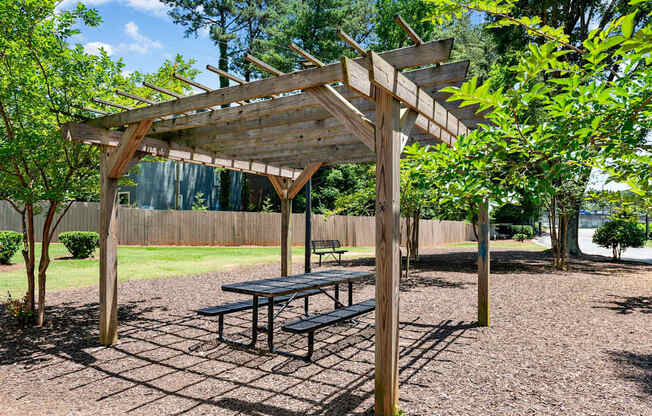 A wooden pergola with a bench at Dunwoody Glen, Atlanta, GA 30360