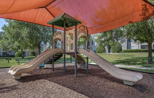 a playground with two slides and a climbing structure