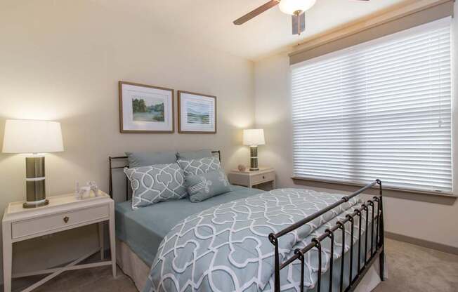 A bedroom with a bed, nightstand, and lamp.