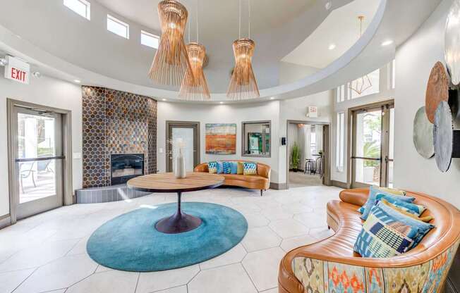 A living room with a blue rug and a brown couch.