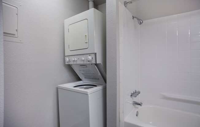 White washer and dryer in a bathroom with a shower and a sink  at Governor's Park, Fort Collins, 80525