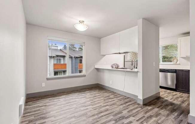 A kitchen area with a window showing a view of a residential area.