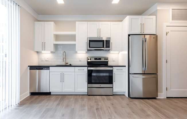 a kitchen with white cabinets and stainless steel appliances