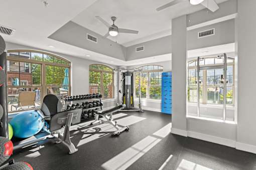 A spacious gym with a variety of equipment and a view of the outdoors.