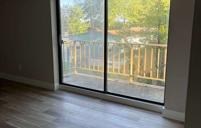 A room with a sliding glass door leading to a balcony.