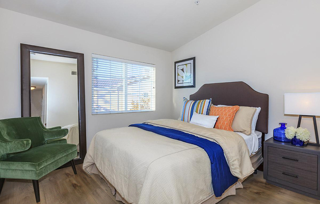 a bedroom with a bed and desk in a room