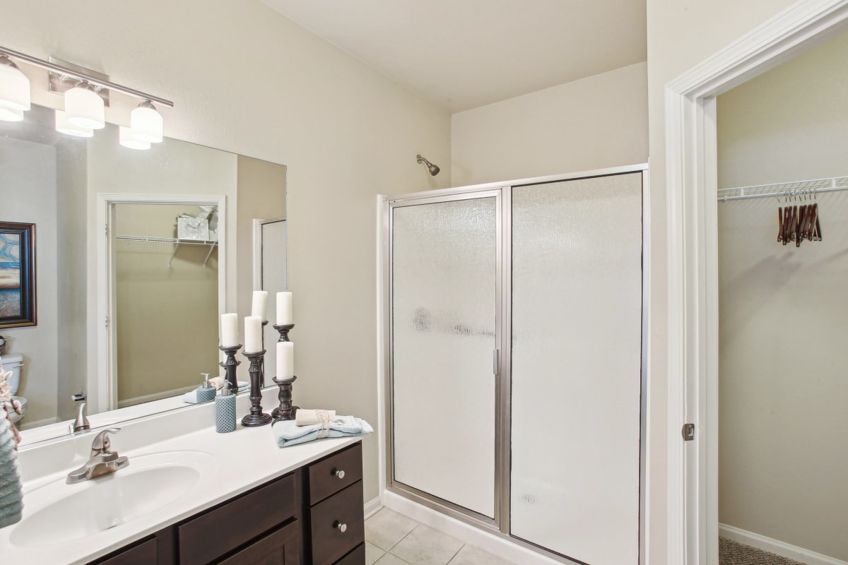 a bathroom with a shower and a sink and a mirror