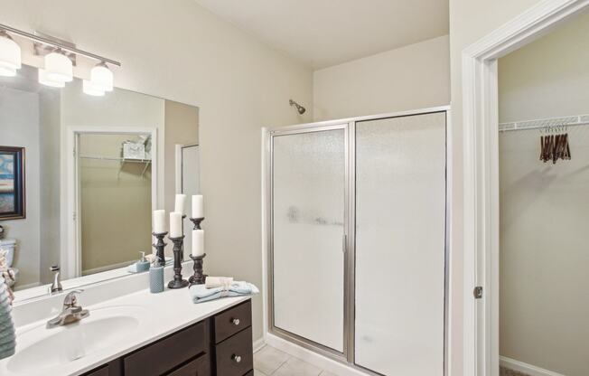 a bathroom with a shower and a sink and a mirror