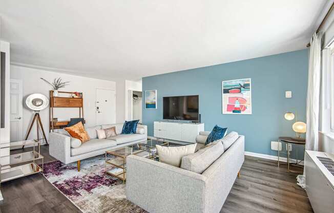 A living room with a grey couch and a white coffee table.
