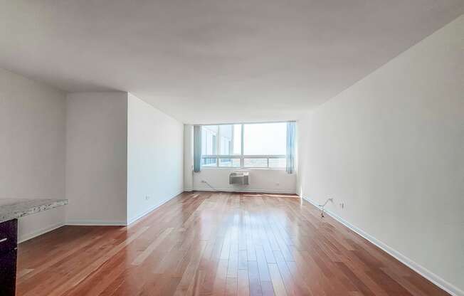 a bedroom with hardwood floors and white walls