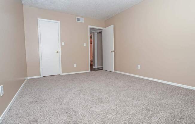 A bedroom room with a carpeted floor and closet  at The Creole Apartments in Shreveport, LA