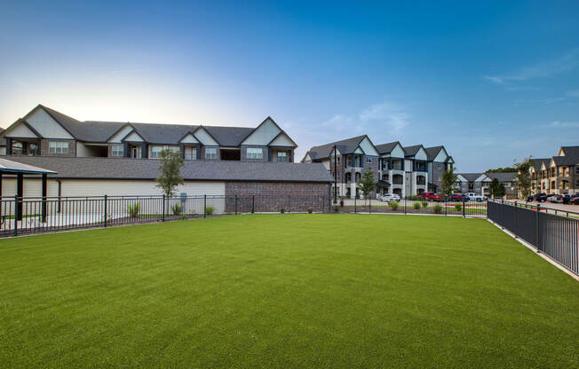 a large green lawn in front of a row of houses