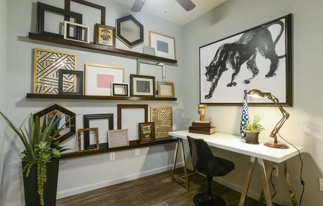 a home office with a desk and pictures on the wall