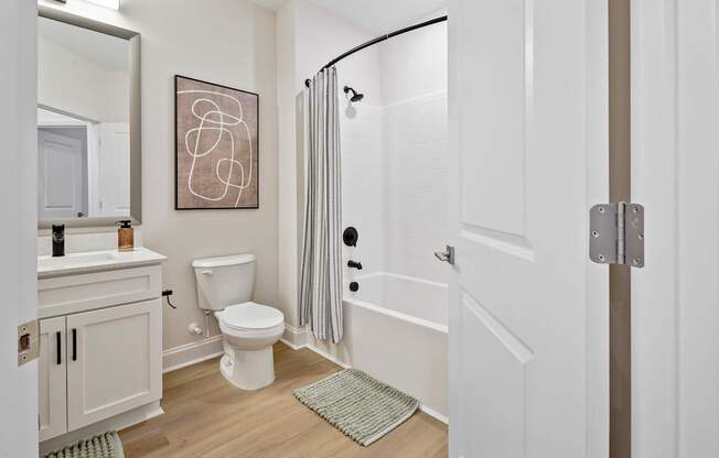 A bathroom with a toilet, sink, and shower.
