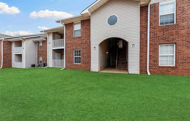 A large house with a green lawn in front.