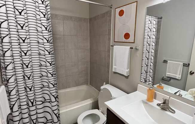 A bathroom with a toilet, sink, and shower.