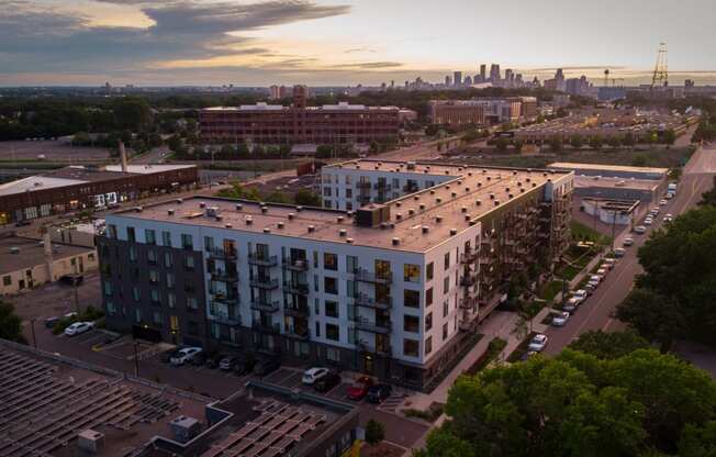 an aerial view of an apartment building with a city skyline in the background