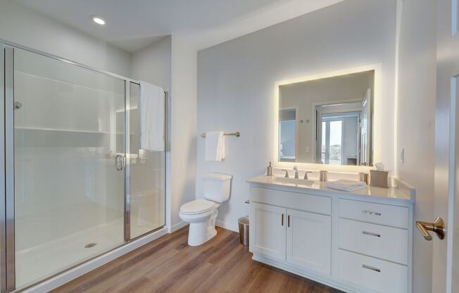 a white bathroom with a shower toilet and sink